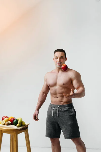 明るい果実と白い背景にポーズをとっているスポーティセクシー男 食事よ 健康的な食事 — ストック写真