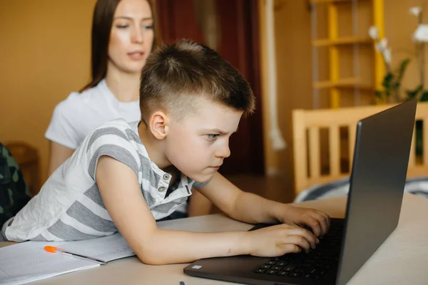 一位母亲和她的孩子在家里的电脑前进行远程学习 待在家里 — 图库照片