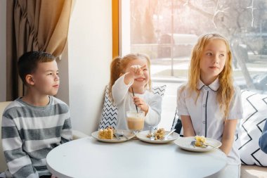 Büyük bir arkadaş canlısı çocuk grubu tatili bir kafede lezzetli bir tatlıyla kutluyor. Doğum günü.