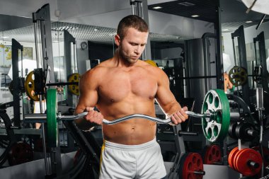 Genç bir sporcu spor salonunda fitness yapıyor. Fitness, vücut geliştirme