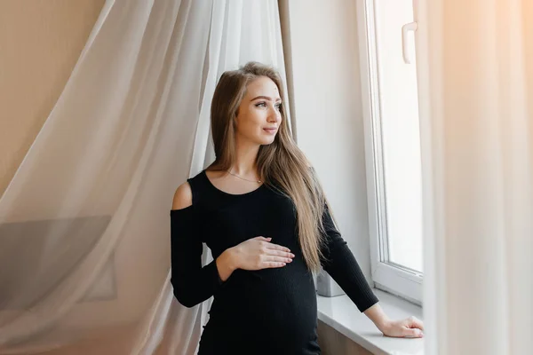 Una Hermosa Embarazada Está Pie Una Habitación Cerca Ventana —  Fotos de Stock