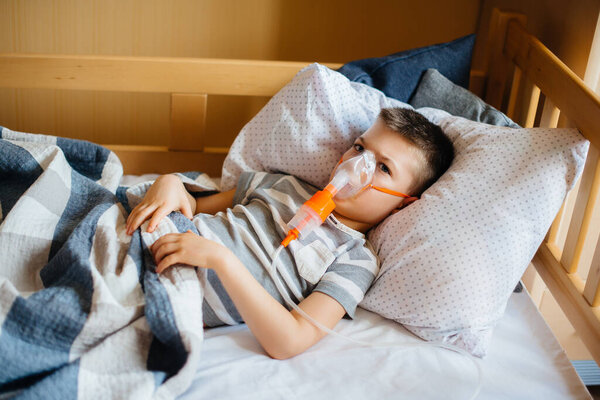 Молодому мальчику делают вдох во время болезни легких. Медицина и уход