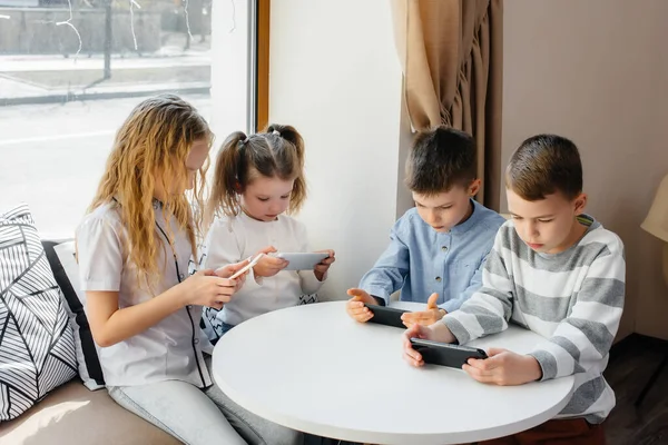 Bambini Siedono Tavolo Caffè Giocano Insieme Telefoni Cellulari Intrattenimento Moderno — Foto Stock