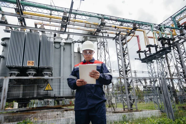 stock image The energy engineer inspects the equipment of the substation. Power engineering. Industry