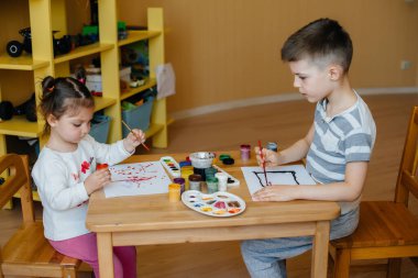 Bir erkek ve bir kız birlikte oynayıp resim yapıyorlar. Eğlence ve eğlence. Evde kal.