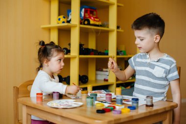 Bir erkek ve bir kız birlikte oynayıp resim yapıyorlar. Eğlence ve eğlence. Evde kal.