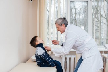 Genç bir çocuk modern bir klinikte deneyimli bir doktor tarafından dinlenir ve tedavi edilir. Bir virüs ve bir salgın.