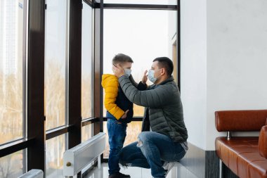 Karantina sırasında çocuklu bir baba maske takıyor. Salgın, koronavirüs.