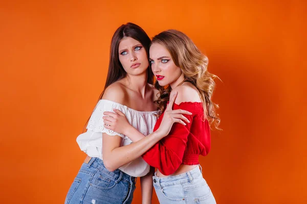 Two Young Beautiful Girls Shows Emotions Smiles Studio Orange Background — Stock Photo, Image