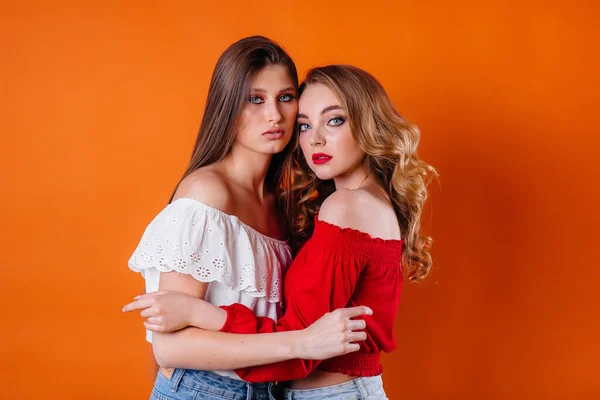 Twee Jonge Mooie Meisjes Tonen Emoties Glimlachen Studio Een Oranje — Stockfoto