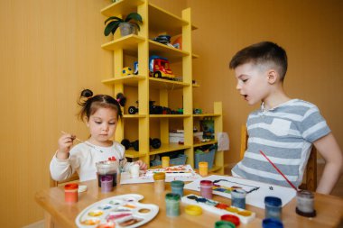 Bir erkek ve bir kız birlikte oynayıp resim yapıyorlar. Eğlence ve eğlence. Evde kal.