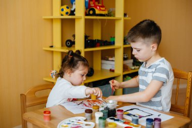 Bir erkek ve bir kız birlikte oynayıp resim yapıyorlar. Eğlence ve eğlence. Evde kal.