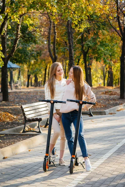 Due Giovani Belle Ragazze Cavalcano Scooter Elettrici Nel Parco Una — Foto Stock