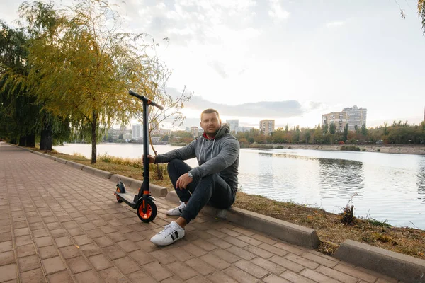 Een Jongeman Rijdt Het Park Een Elektrische Scooter Een Warme — Stockfoto