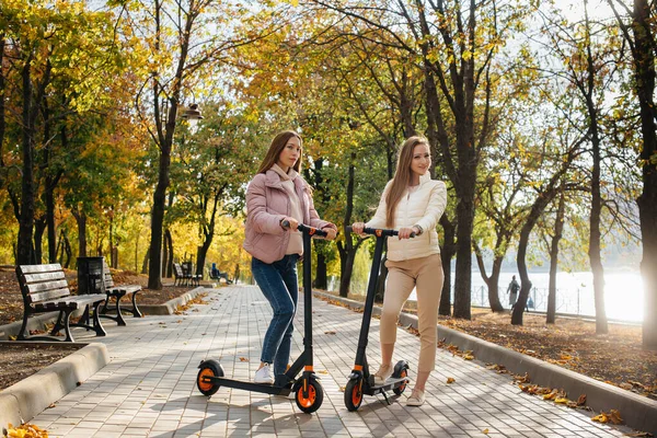 Теплий Осінній День Двоє Гарних Дівчат Їдуть Електричних Скутерах Парку — стокове фото