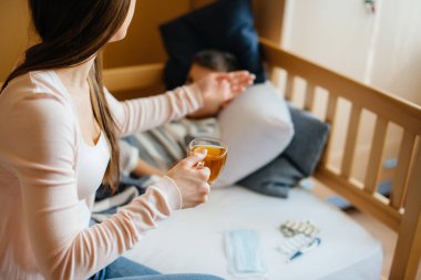 Anne hastalık ve virüs sırasında bebeğine limonlu sıcak çay verir. İlaç ve bakım