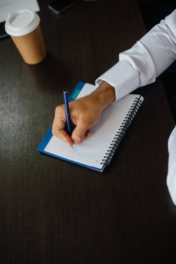 Not defterine düşüncelerini ve fikirlerini yazan bir adamın yakın çekimi.