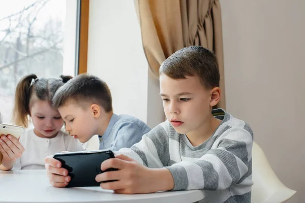 Children Sit Table Cafe Play Mobile Phones Together Modern Entertainment — Stock Photo, Image