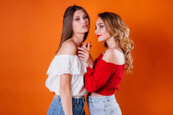 Two Young Beautiful Girls Shows Emotions Smiles Studio Orange Background — Stock Photo, Image