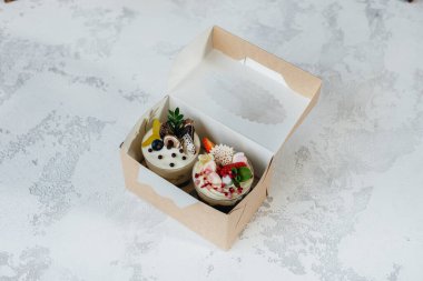 İki güzel ve lezzetli pastanın arka planda bir hediye kutusunda yakın plan fotoğrafı. Tatlı, sağlıklı yemek.