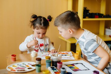 Bir erkek ve bir kız birlikte oynayıp resim yapıyorlar. Eğlence ve eğlence. Evde kal.