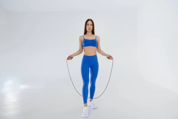 Sexy Joven Saltando Cuerda Chándal Azul Sobre Fondo Blanco Fitness — Foto de Stock