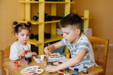 Bir erkek ve bir kız birlikte oynayıp resim yapıyorlar. Eğlence ve eğlence. Evde kal.