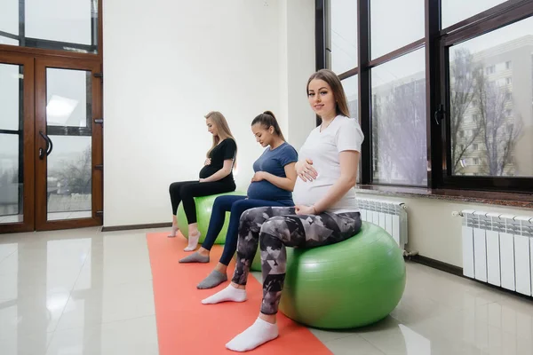 若い妊婦のグループはフィットネスクラブでピラティスやボールスポーツに従事しています — ストック写真