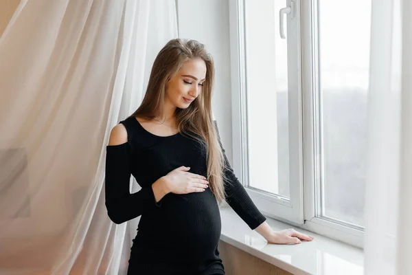 Vacker Gravid Flicka Står Ett Rum Nära Fönstret — Stockfoto