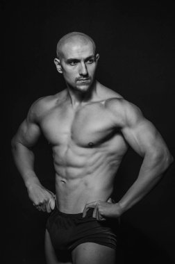 Arka planda Stüdyoda poz veren sporcu. Spor, güzellik, siyah beyaz fotoğraf