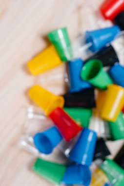 Zemine saçılmış geniş renkli plastik bardaklar yığını, odak dışı. Çevrenin insan atıklarıyla kirlenmesi