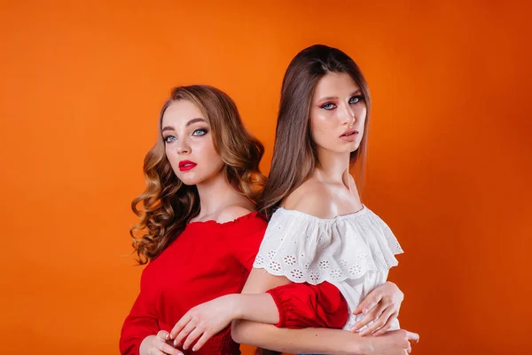 Duas Meninas Jovens Bonitas Mostram Emoções Sorrisos Estúdio Fundo Laranja — Fotografia de Stock