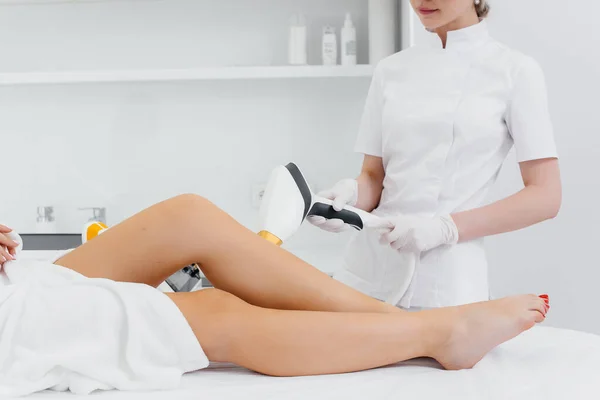 A beautiful young girl will undergo laser hair removal with modern equipment in a Spa salon. Beauty salon. Body care