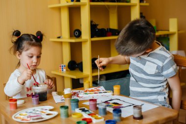 Bir erkek ve bir kız birlikte oynayıp resim yapıyorlar. Eğlence ve eğlence. Evde kal.