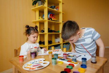 Bir erkek ve bir kız birlikte oynayıp resim yapıyorlar. Eğlence ve eğlence. Evde kal.