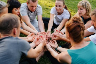 Bir grup insan gün batımında açık havada yoga yapıyor. Sağlıklı yaşam tarzı, meditasyon ve sağlık