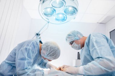 Modern bir ameliyathane, yakın çekim, acil kurtarma ve hastanın canlandırılması. İlaç ve ameliyat.