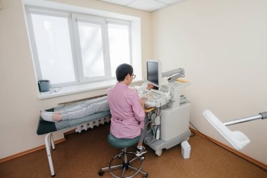 Hamile bir kız klinikte karnının ultrasonuna giriyor. Tıbbi muayene