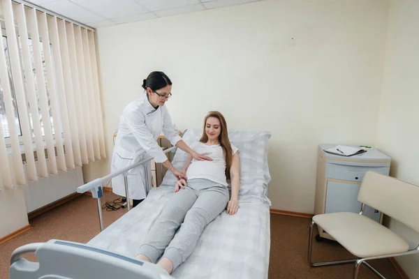 医者は若い妊婦を診療所で助言し 提供しています 健康診断 — ストック写真