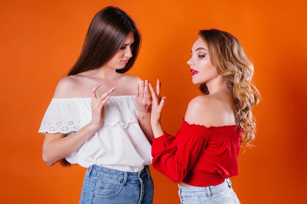 Duas Meninas Jovens Bonitas Mostram Emoções Sorrisos Estúdio Fundo Laranja — Fotografia de Stock