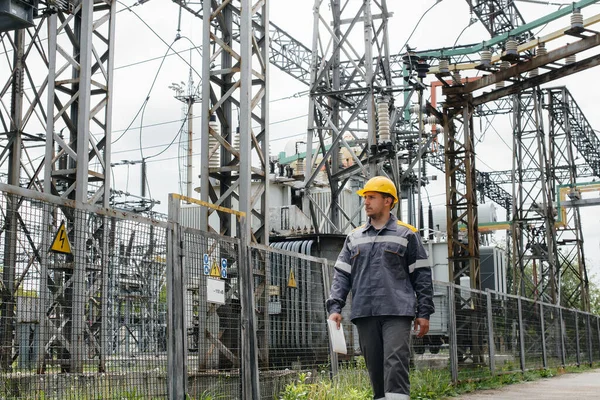 An engineering employee makes a tour and inspection of a modern electrical substation. Energy. Industry