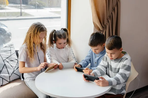 Bambini Siedono Tavolo Caffè Giocano Insieme Telefoni Cellulari Intrattenimento Moderno — Foto Stock