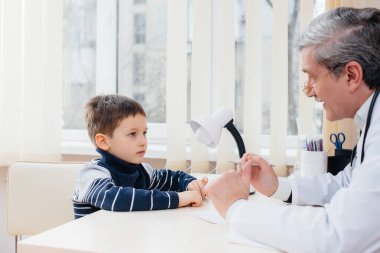 Genç bir çocuk modern bir klinikte deneyimli bir doktor tarafından dinlenir ve tedavi edilir. Bir virüs ve bir salgın.