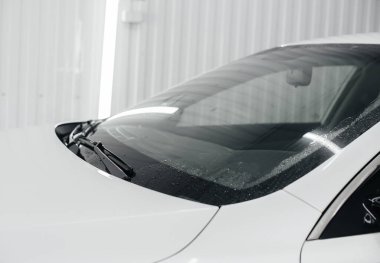 Köpüklü modern yıkama ve beyaz bir arabanın yüksek basınçlı suyu. Araba yıkama