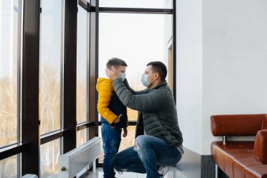 Karantina sırasında çocuklu bir baba maske takıyor. Salgın, koronavirüs.