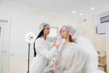 Genç ve güzel bir kız için biyo-evrizasyon ve kırışıklıkların giderilmesi için kozmetik prosedür. Kozmetoloji.