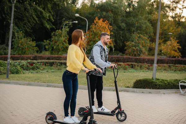 Egy Fiatal Gyönyörű Pár Elektromos Robogózik Parkban Egy Meleg Őszi — Stock Fotó