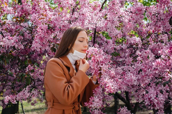 少女はマスクを脱ぎ 春の晴れた日に 庭の開花の前にパンデミックの終わりの後に深く呼吸します 保護と予防 Covid — ストック写真