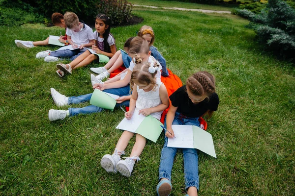 教師は屋外公園で子供たちのクラスを教えています 学校に戻り パンデミック時に学び — ストック写真