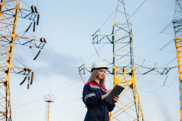 A young engineering worker inspects and controls the equipment of the power line. Energy